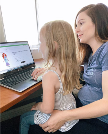 Girl Sitting on Mom's Lap Looking at Computer