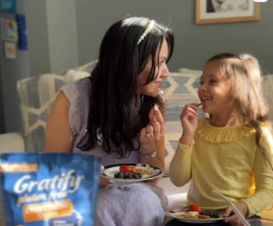 Mom and child sharing a real-life snack moment at home, reflecting how Gen Z moms rely on authentic peer experience and trust when researching products on Reddit.